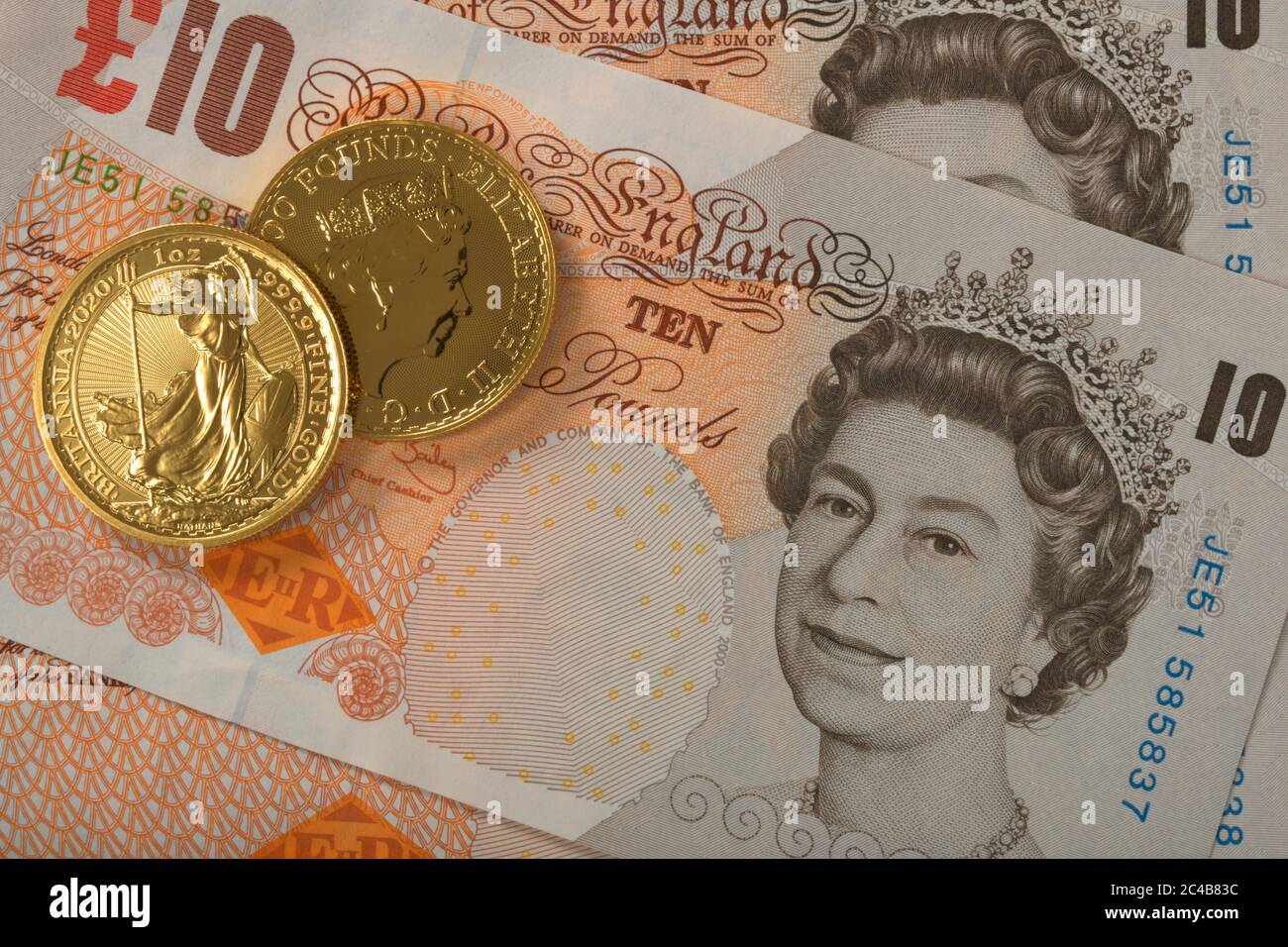 Goldmünzen, 1 Unze, Britannia Vorderseite und Rückseite Königin Elizabeth II, auf 10 Pfund Sterling Banknote Stockfoto