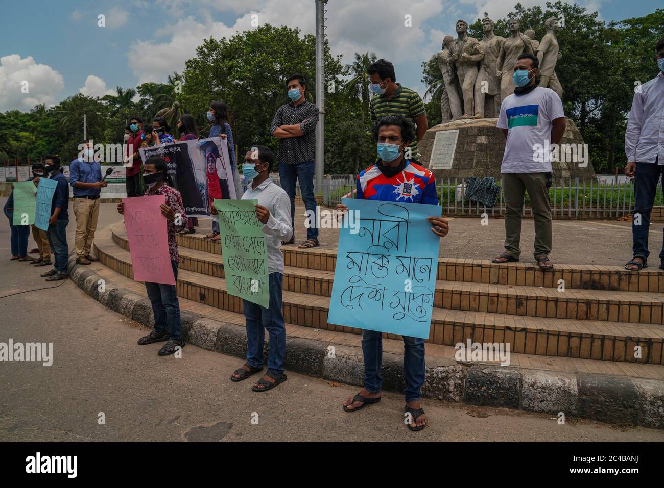 Während der Demonstration halten Demonstranten mit Gesichtsmasken Plakate.Studenten der Dhaka University haben einen Protest der Menschenkette gegen den Mord an Sumaiya, einem Studenten des Departments für Islamwissenschaft, in der Raju Memorial Sculpture nahe der Dhaka University in Dhaka veranstaltet. Stockfoto