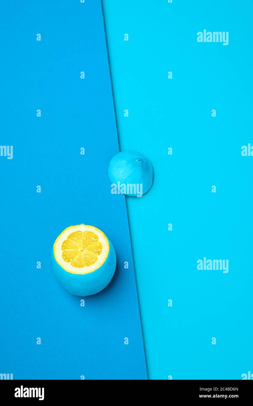 Außen auf blauem Hintergrund mit Zitrone bemaltes Cyan. Zitronenscheiben oben. Kontrastierende Farben mit Zitronengelb, Blau und Cyan. Zitrusfrüchte wi Stockfoto