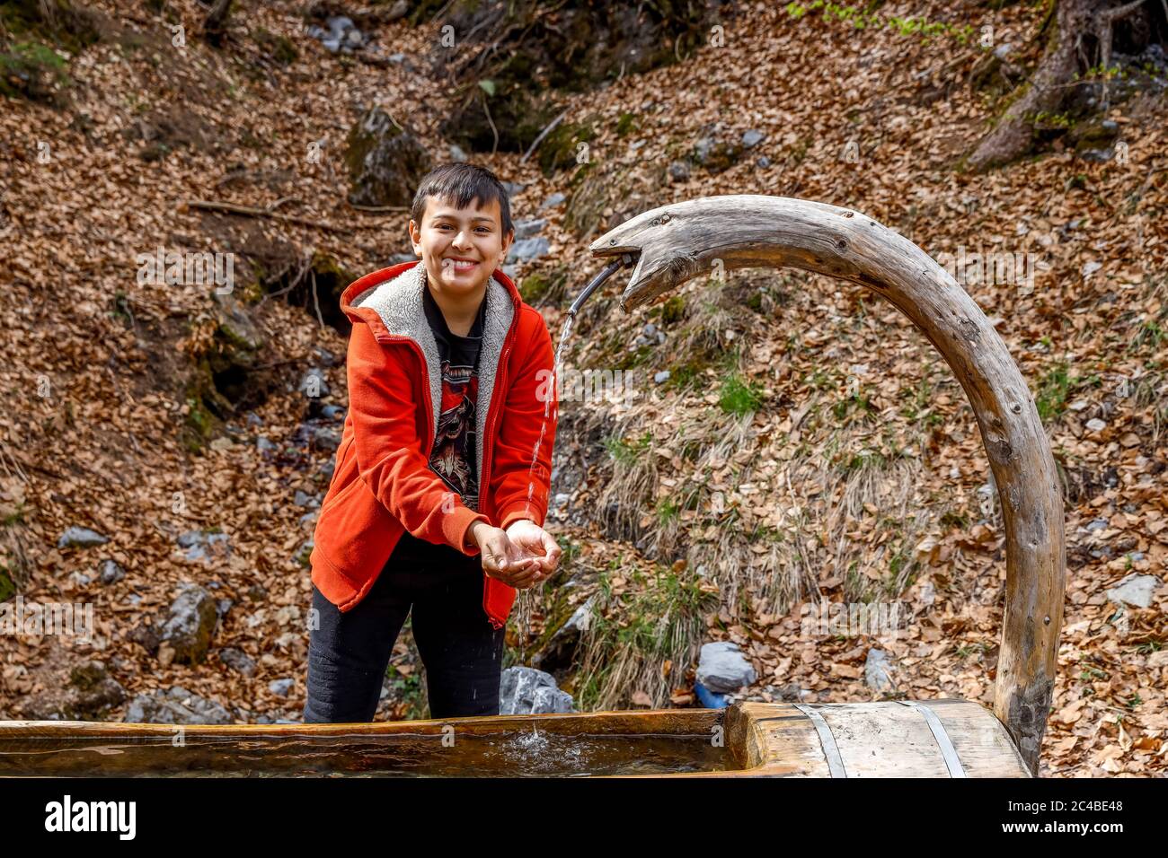 13-jähriger Junge, der in Haute savoie, frankreich, frisches Wasser bekommt Stockfoto