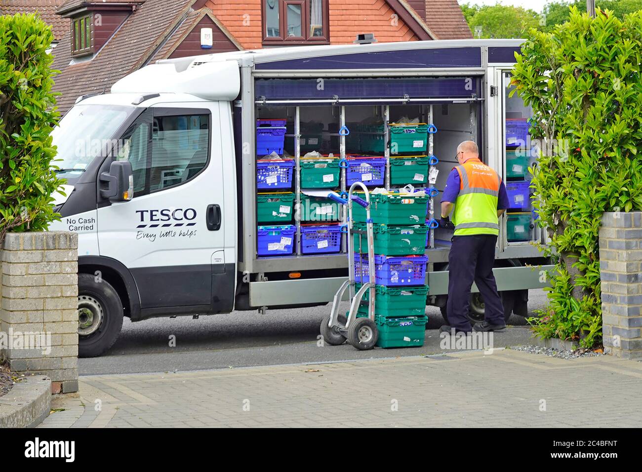 Tesco Supermarkt online Internet Supply Chain Home Lebensmittel Einkaufen auf Lieferung van Fahrer sortiert vor der Platzierung an Haus Tür Essex England UK Stockfoto