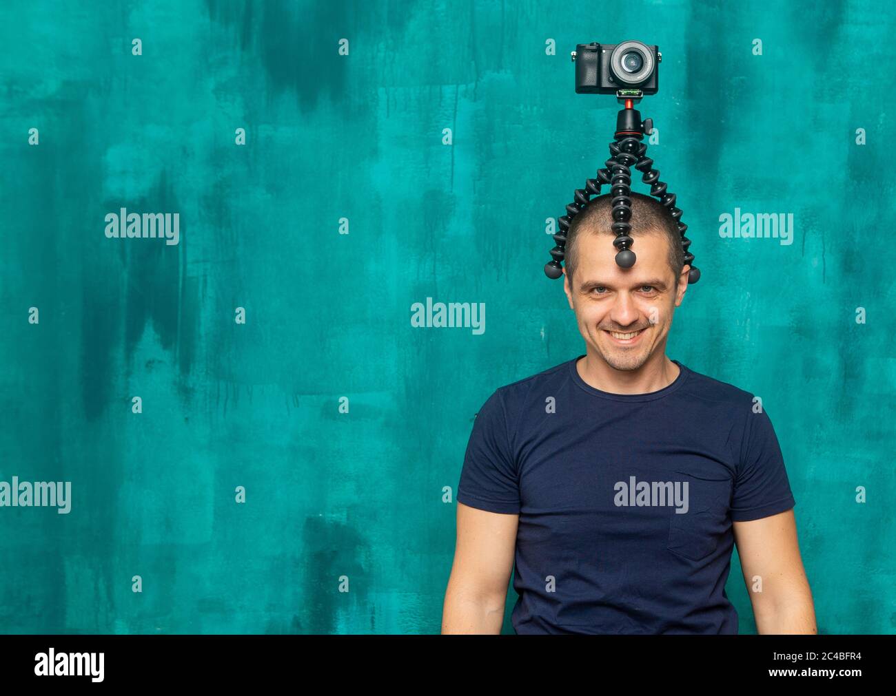 Lustiger Mann Blogger, Fotoapparat und Videofilmer mit Kamera auf dem Kopf Stockfoto
