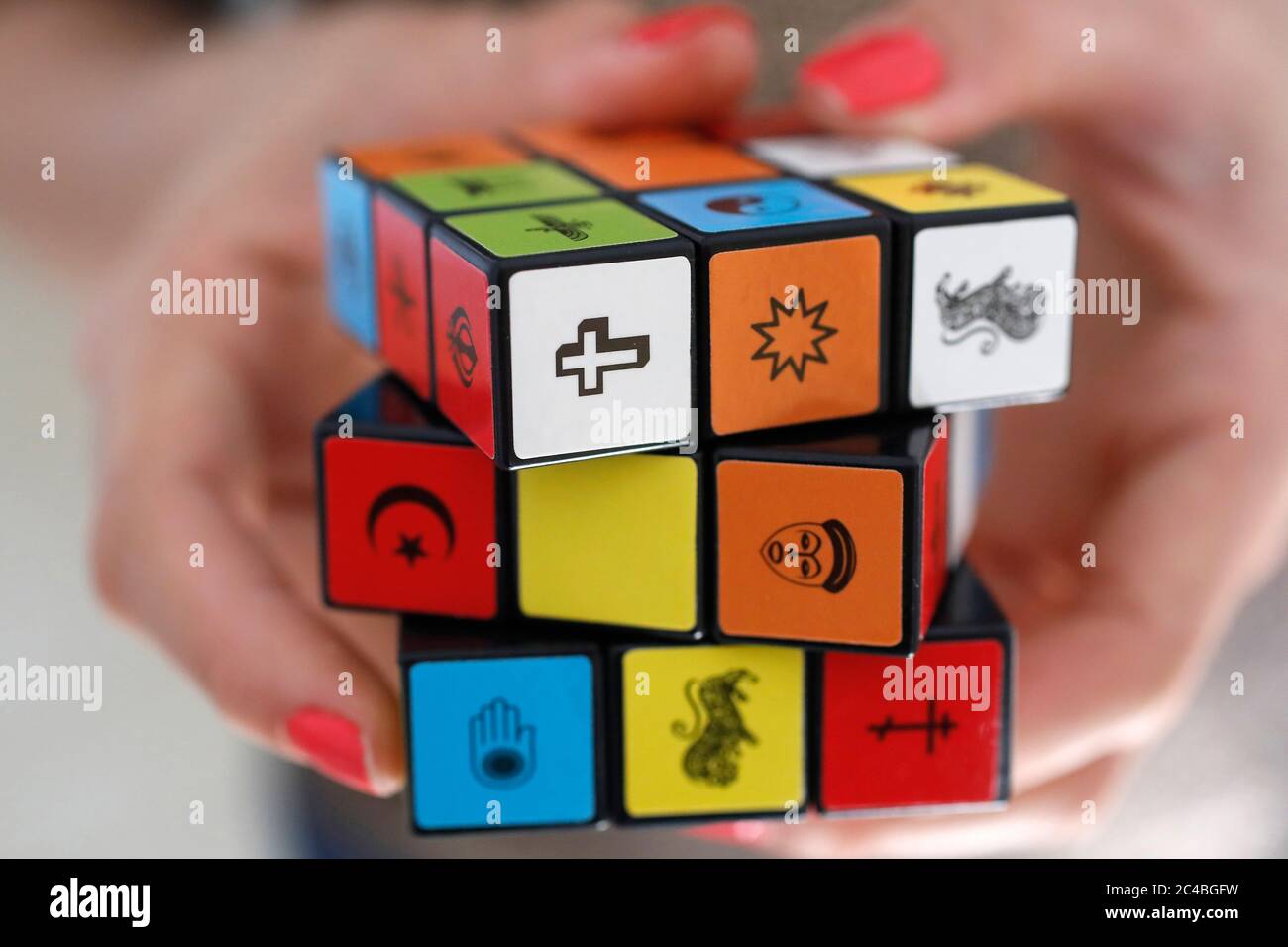 Frau mit einem rubik-Würfel mit religiösen Symbolen Stockfoto