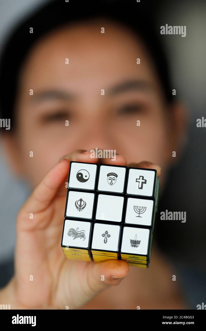 Frau mit einem rubik-Würfel mit religiösen Symbolen Stockfoto