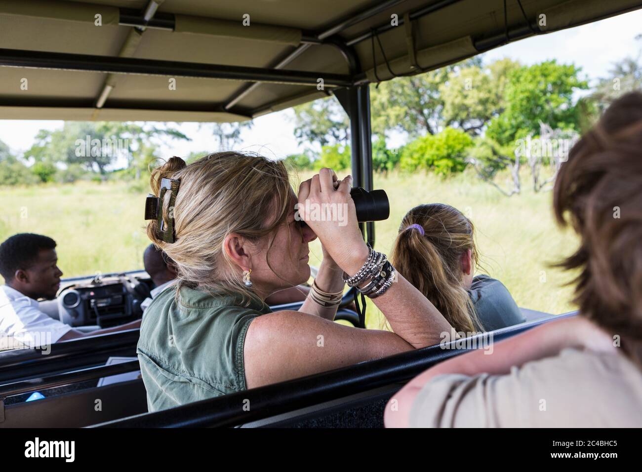 Erwachsene Frau mit Fernglas im Safarifahrzeug, Botswana Stockfoto