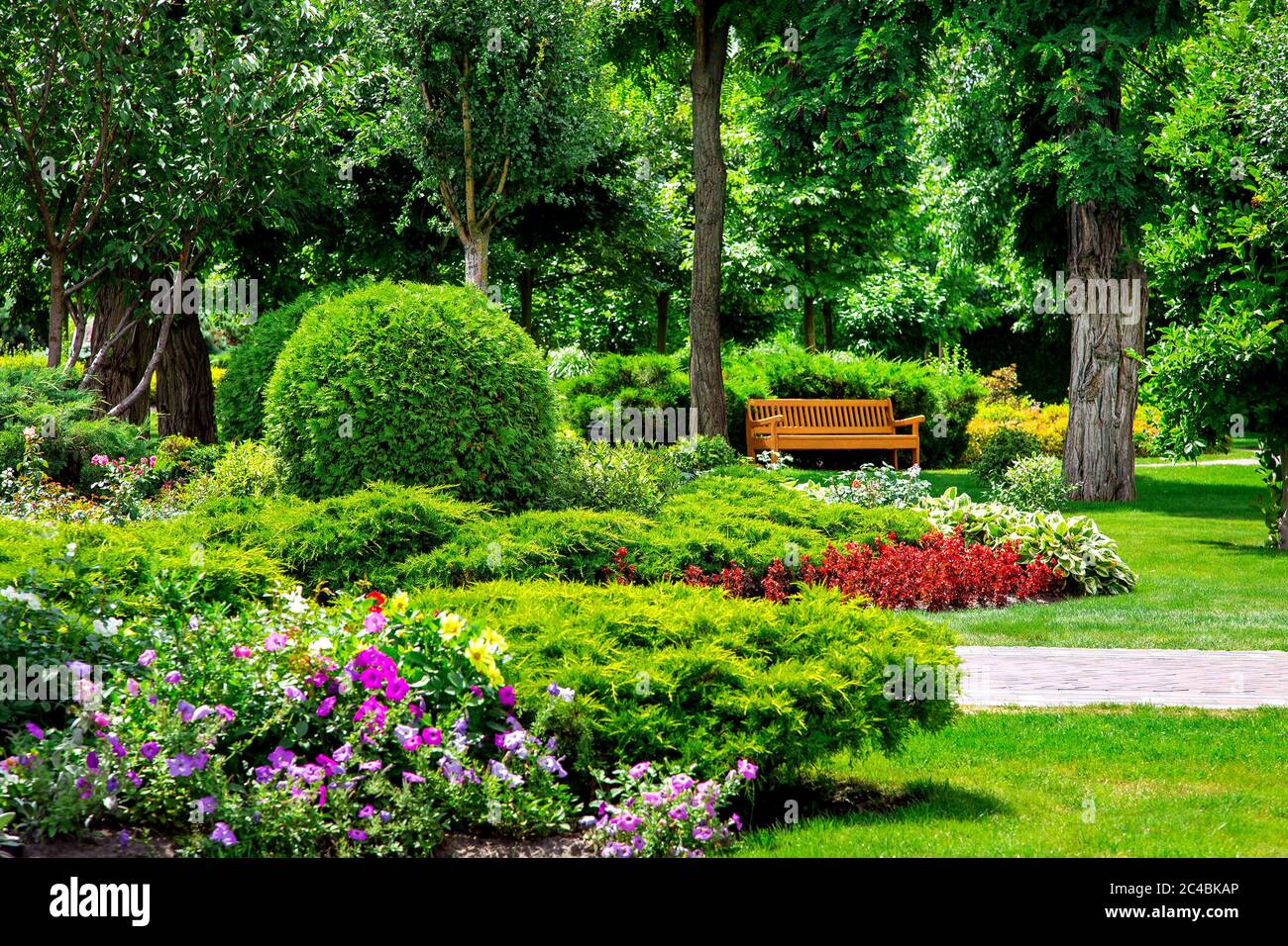 Blumenbeet mit Pflanzen in einem Sommerpark mit Wegen und leeren