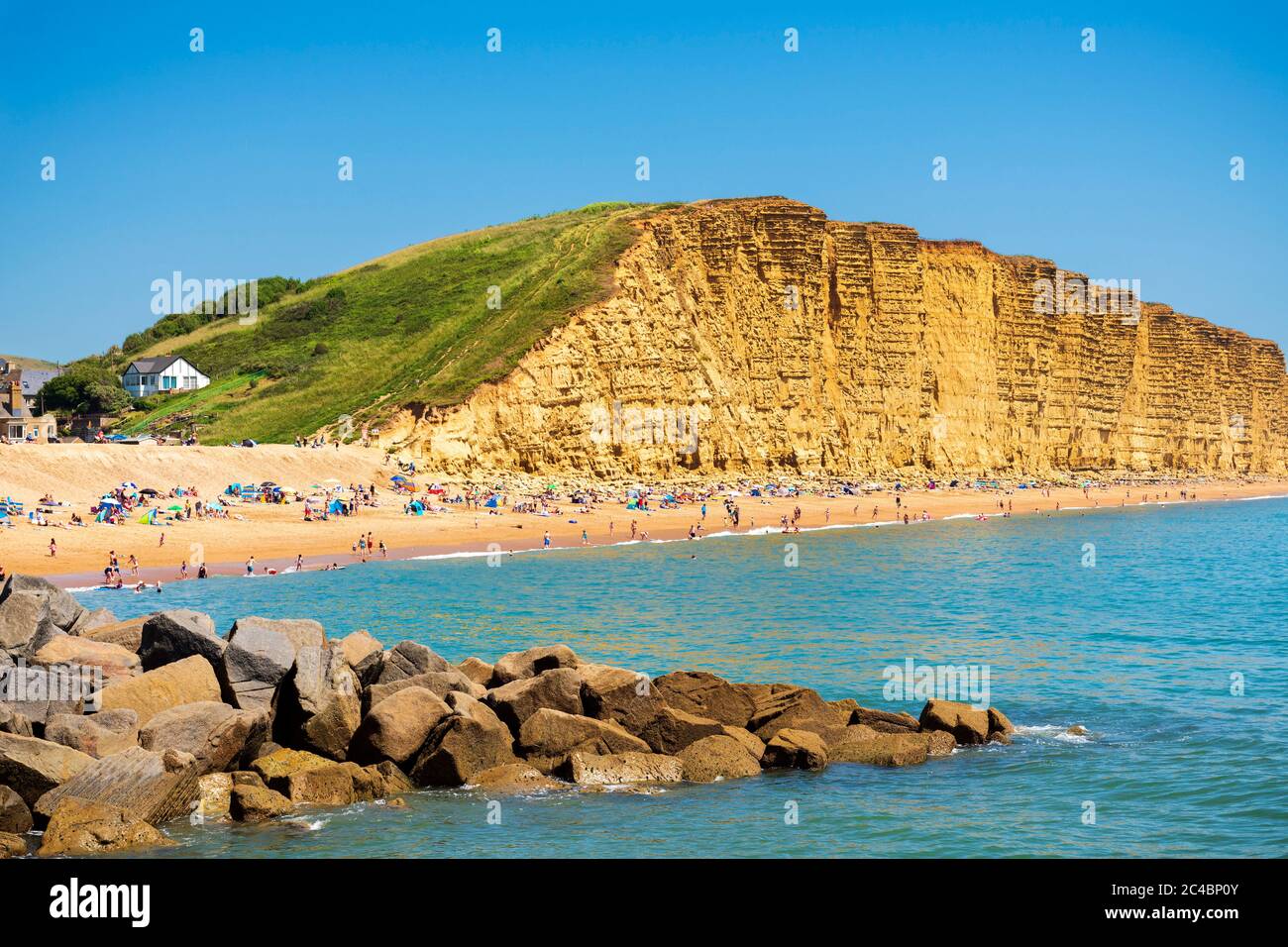 West Bay Dorset am Meer mit Menschen genießen das Sommerwetter am Strand, Großbritannien. Stockfoto