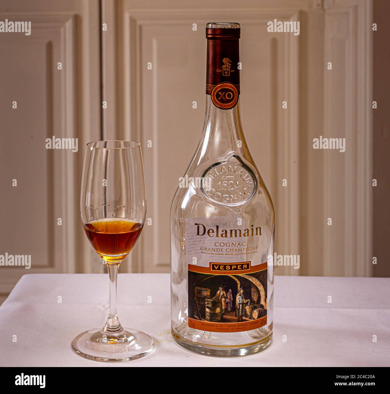 Eine Flasche Delamain Vesper XO Grande Champagne Cognac steht neben einem gefüllten Glas im Hotel und Restaurant Kronenschlösschen in Hattenheim, Eltville am Rhein, Hessen, Deutschland. Der Cognac ist das Digestif beim Galadinner des mit einem Michelin-Stern ausgezeichneten Kochs Nick Bril am 26. Februar 2017, Teil des 21. Rheingau Gourmet & Wein Festivals. Die Prägung auf der Flasche gibt 1824 als Gründungsjahr des Hauses Delamain in Jarnac, Frankreich, an. Grande Champagne gilt als der Premier Cru der Cognac-Region. Bril ist Küchenchef des The Jane in Antwerpen, Belgien. Er eröffnete es 2014 mit Sergio Herman i Stockfoto