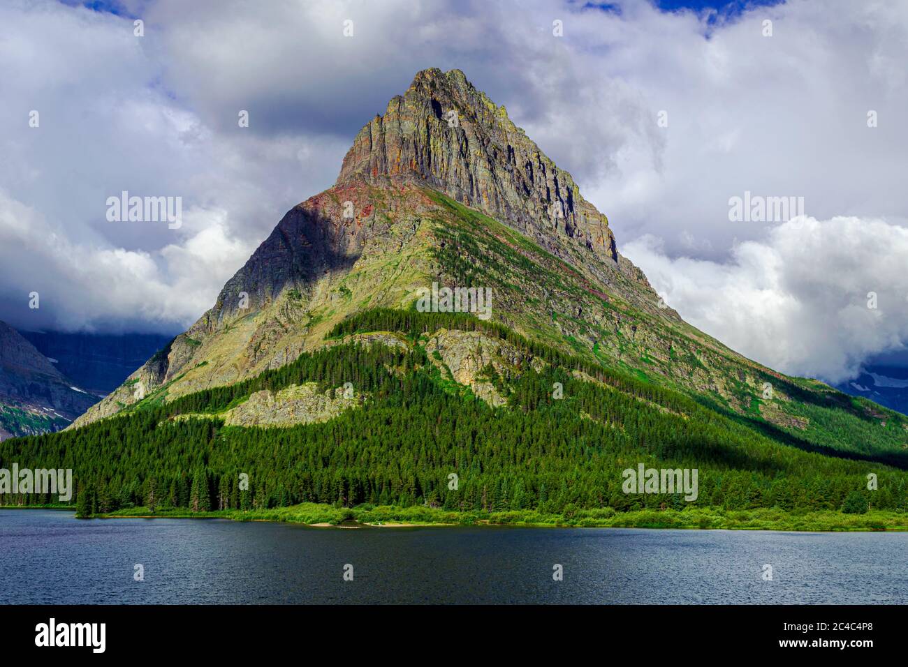 5044 Grinnell Point steht vor einer Wolkenkulisse am Swiftcurrent Lake des Glacier National Park Stockfoto