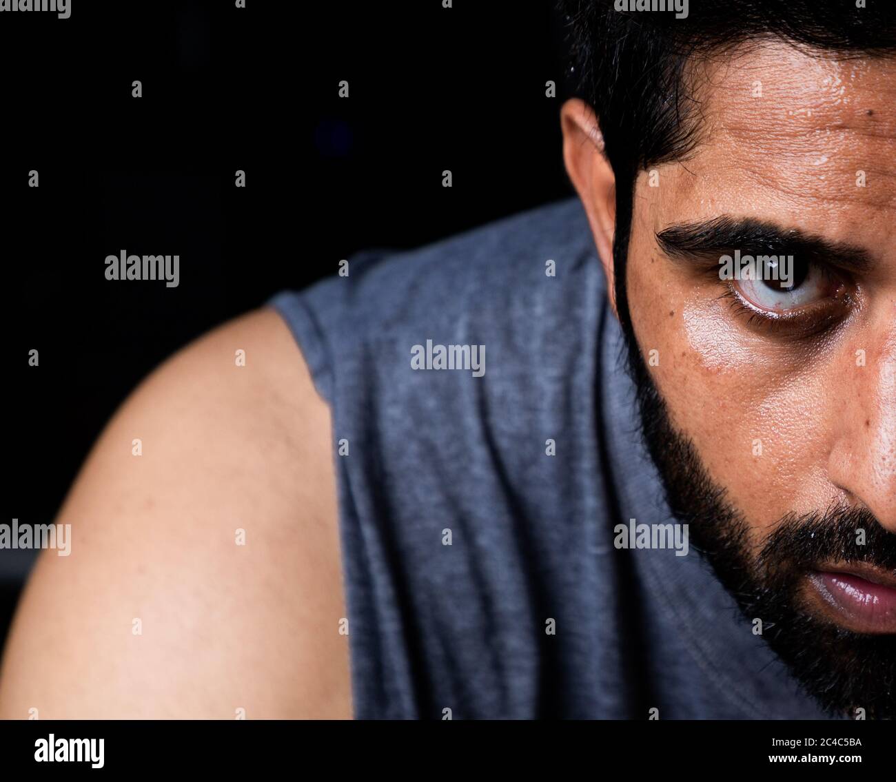 Extreme Nahaufnahme von Hälfte Gesicht des Bartmenschen mit Wut auf den Augen Stockfoto