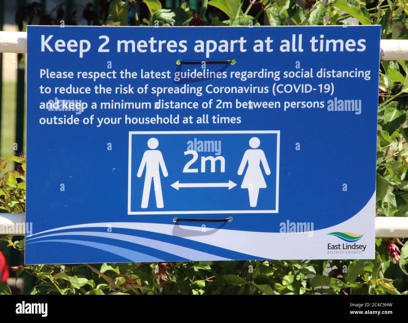 Skegness, Großbritannien. Juni 2020. Ein Schild, das die Menschen daran erinnert, einen sicheren Abstand am Strand zu halten.die Menschen gehen zum Strand im beliebten Badeort Skegness, da England mit Temperaturen von 30 Grad Celsius den heißesten Tag des Jahres verzeichnet. Kredit: SOPA Images Limited/Alamy Live Nachrichten Stockfoto