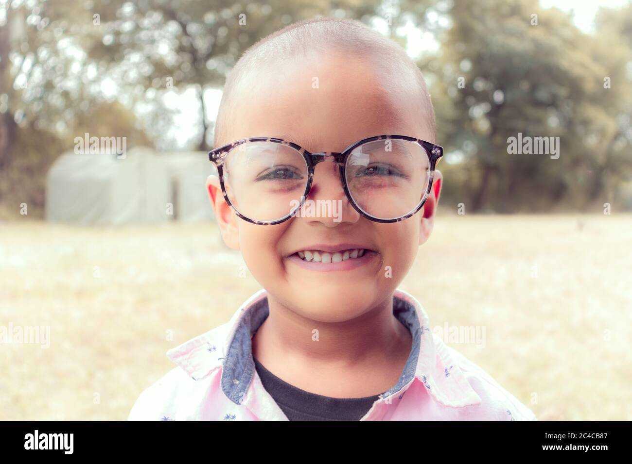 Lächelndes Kind mit großen Gläsern Stockfoto