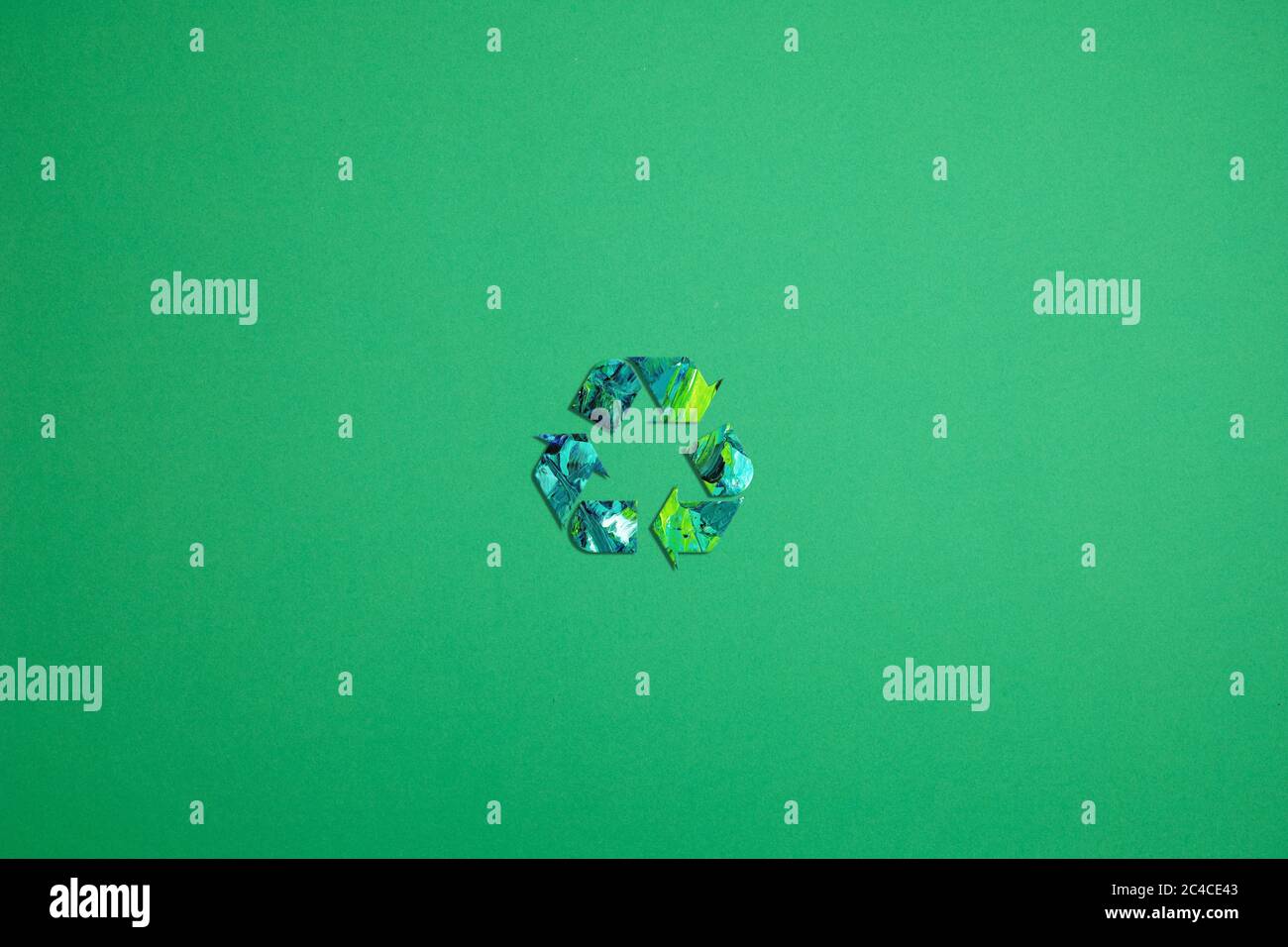 Recycling-Symbol aus Papier mit Farbe auf grünem Hintergrund. Stockfoto