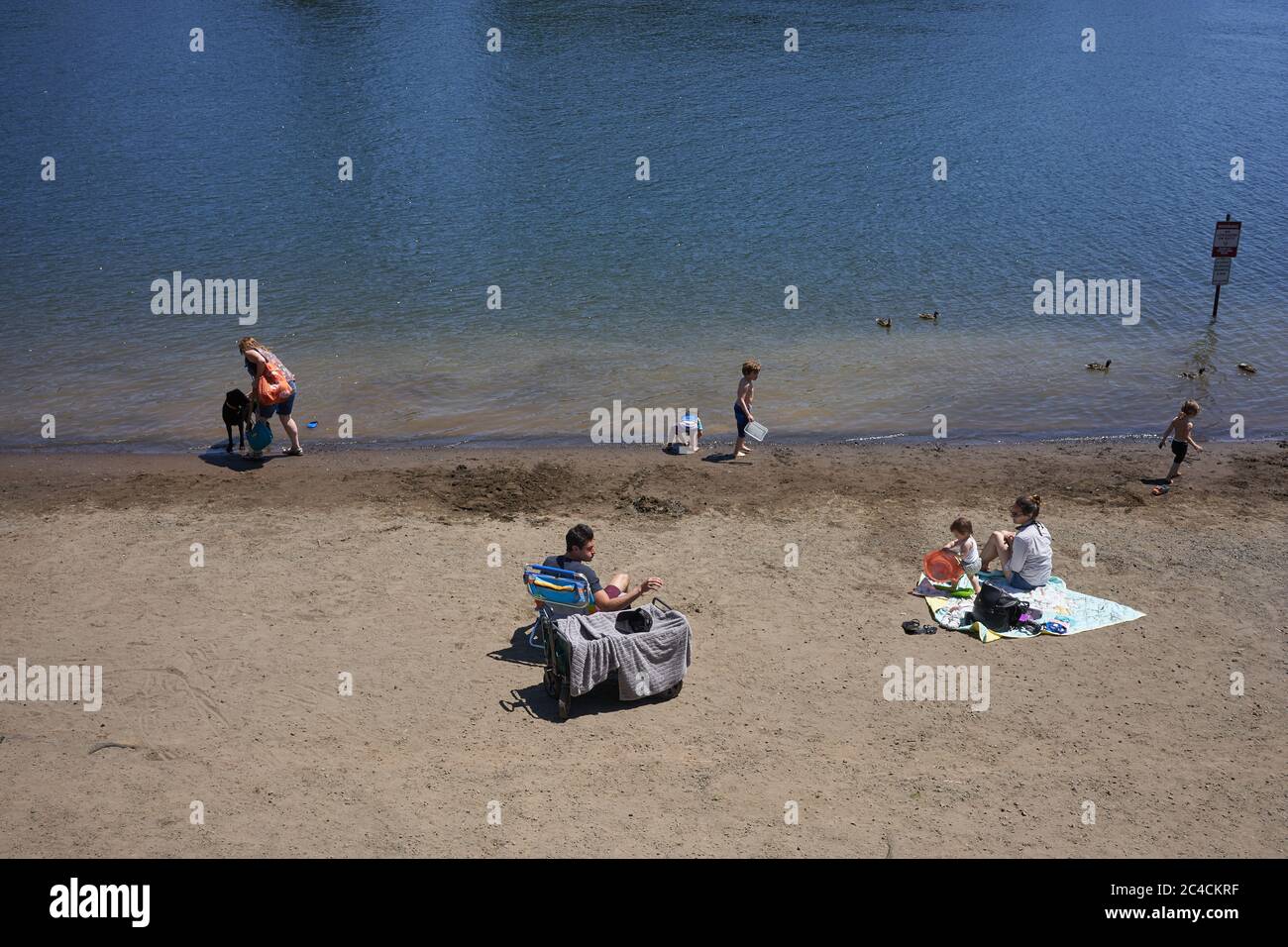 Familien genießen die Natur an einem Strand am Willamette River in Lake Oswego, Oregon, während der Sommer inmitten der Coronavirus-Pandemie am 25. Juni 2020 beginnt. Stockfoto