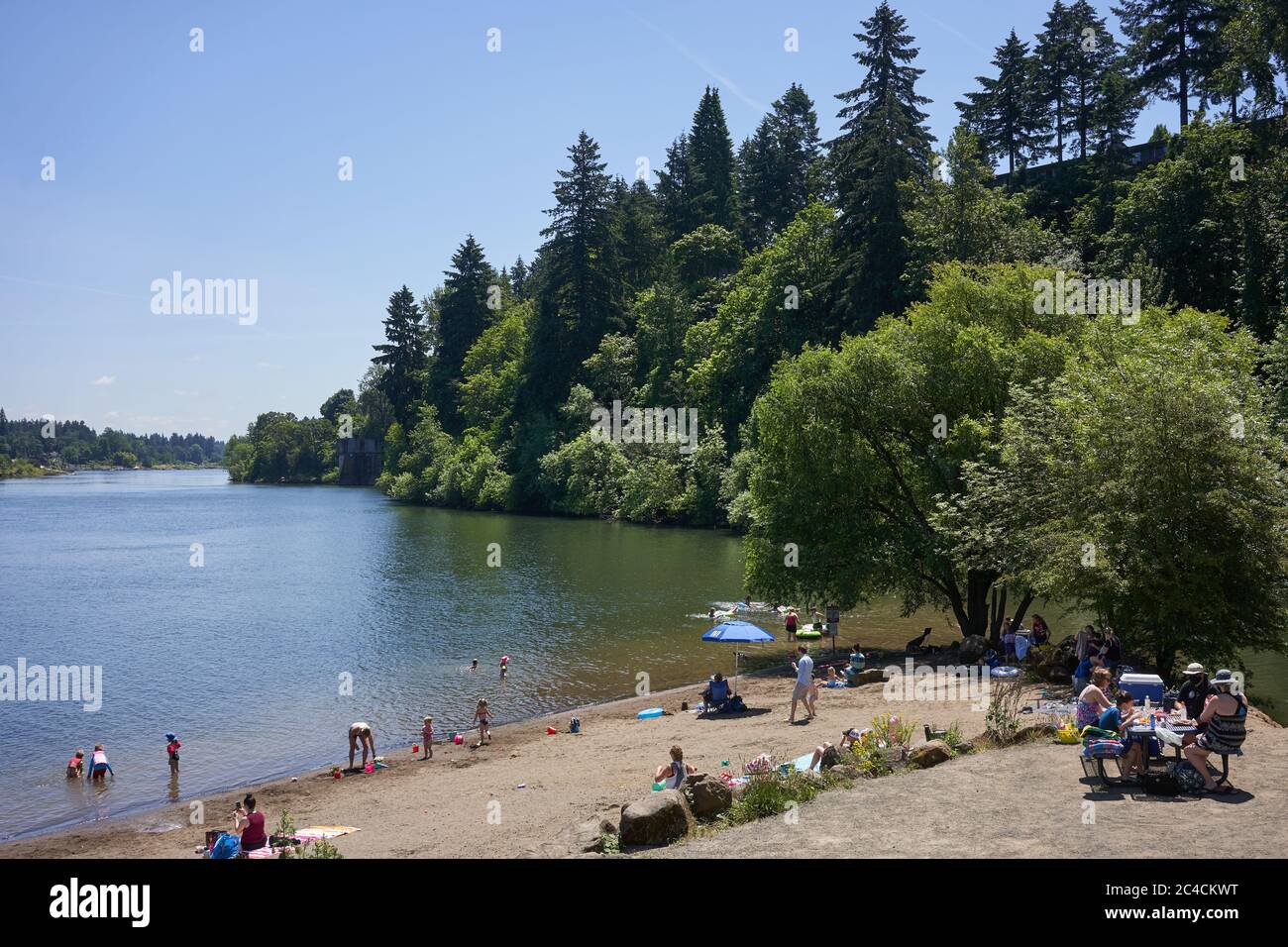 Familien genießen die Natur an einem Strand am Willamette River in Lake Oswego, Oregon, während der Sommer inmitten der Coronavirus-Pandemie am 25. Juni 2020 beginnt. Stockfoto
