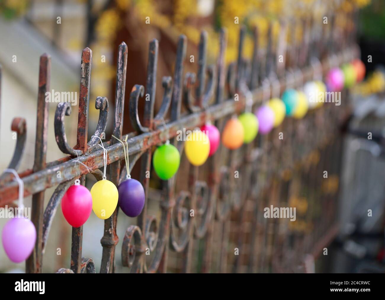 Bunt gefärbte Ostereier hängen in einer Reihe an einem alten Gartenzaun, Bremen Stockfoto