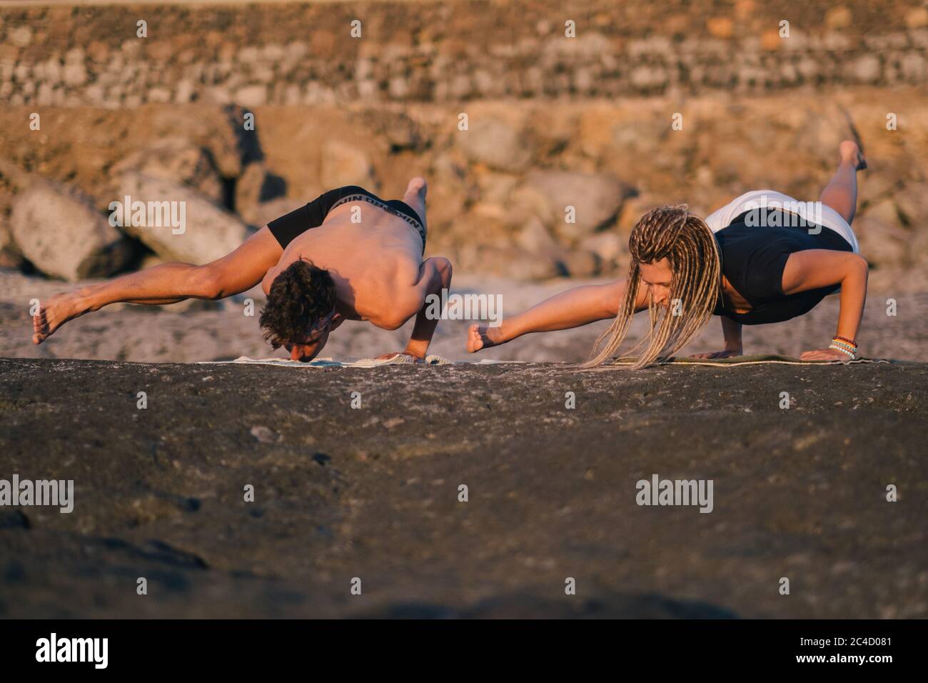Fitness, Sport und Lifestyle-Konzept - Paar macht Yoga-Übungen am Strand Stockfoto