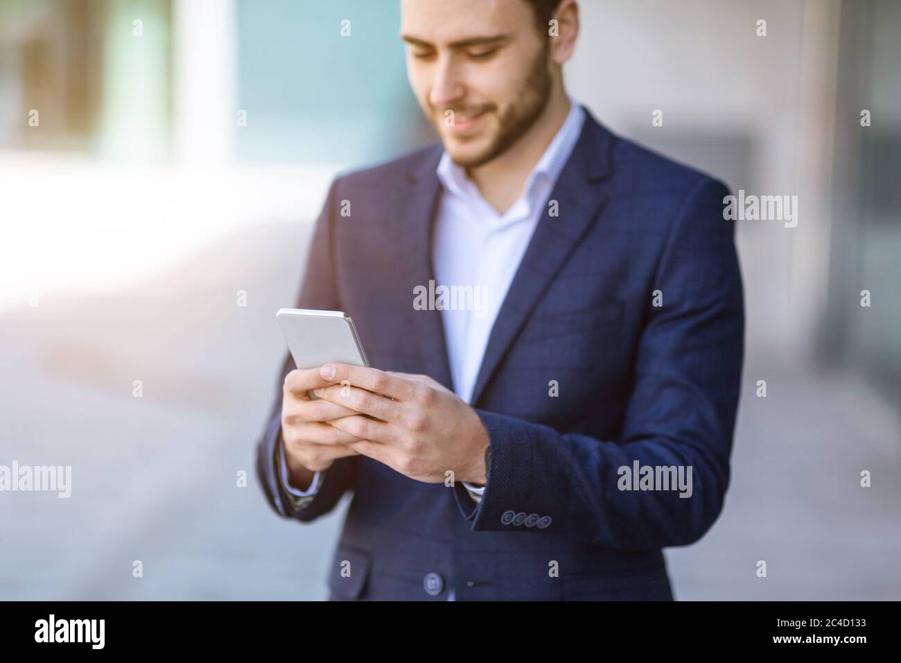 Millennial Business Agent kommuniziert online über das Mobiltelefon auf der Straße der Stadt Stockfoto