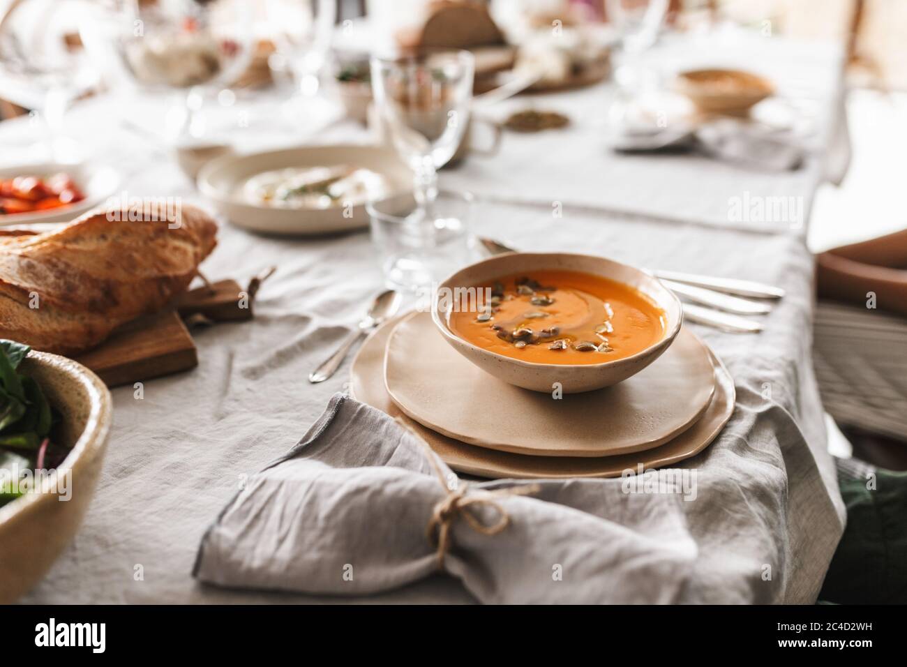Nahaufnahme Schüssel mit Sahne Kürbis Suppe auf dem Tisch voller Essen auf dem Mittagessen in gemütlichen Café Stockfoto