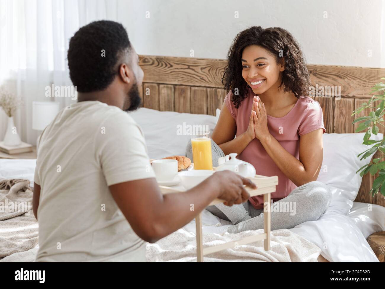 Ehemann überraschend Frau mit Frühstück im Bett Stockfoto