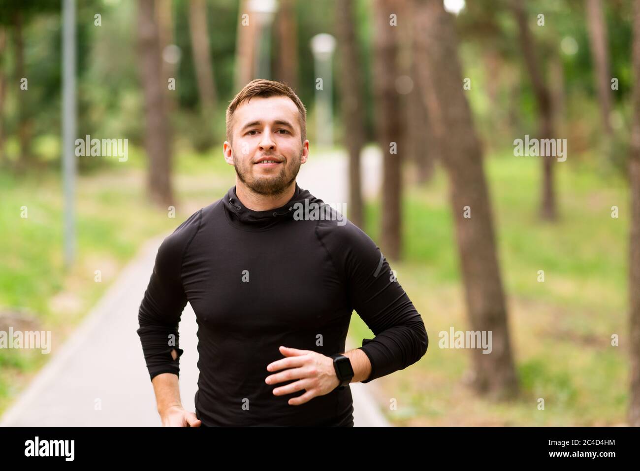 Mann Läufer Joggen auf der Straße, Blick auf die Kamera Stockfoto