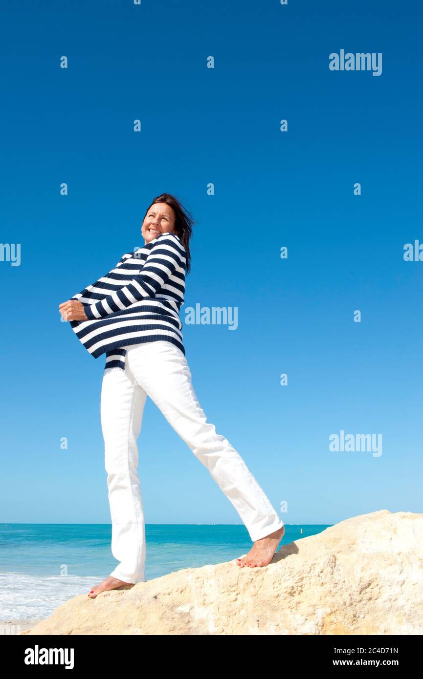 Glücklich selbstbewusst und attraktiv Senior Frau fröhlich aktiven Ruhestand Urlaub auf See, isoliert mit Meer und blauen Himmel als Hintergrund und Kopierer Raum. Stockfoto
