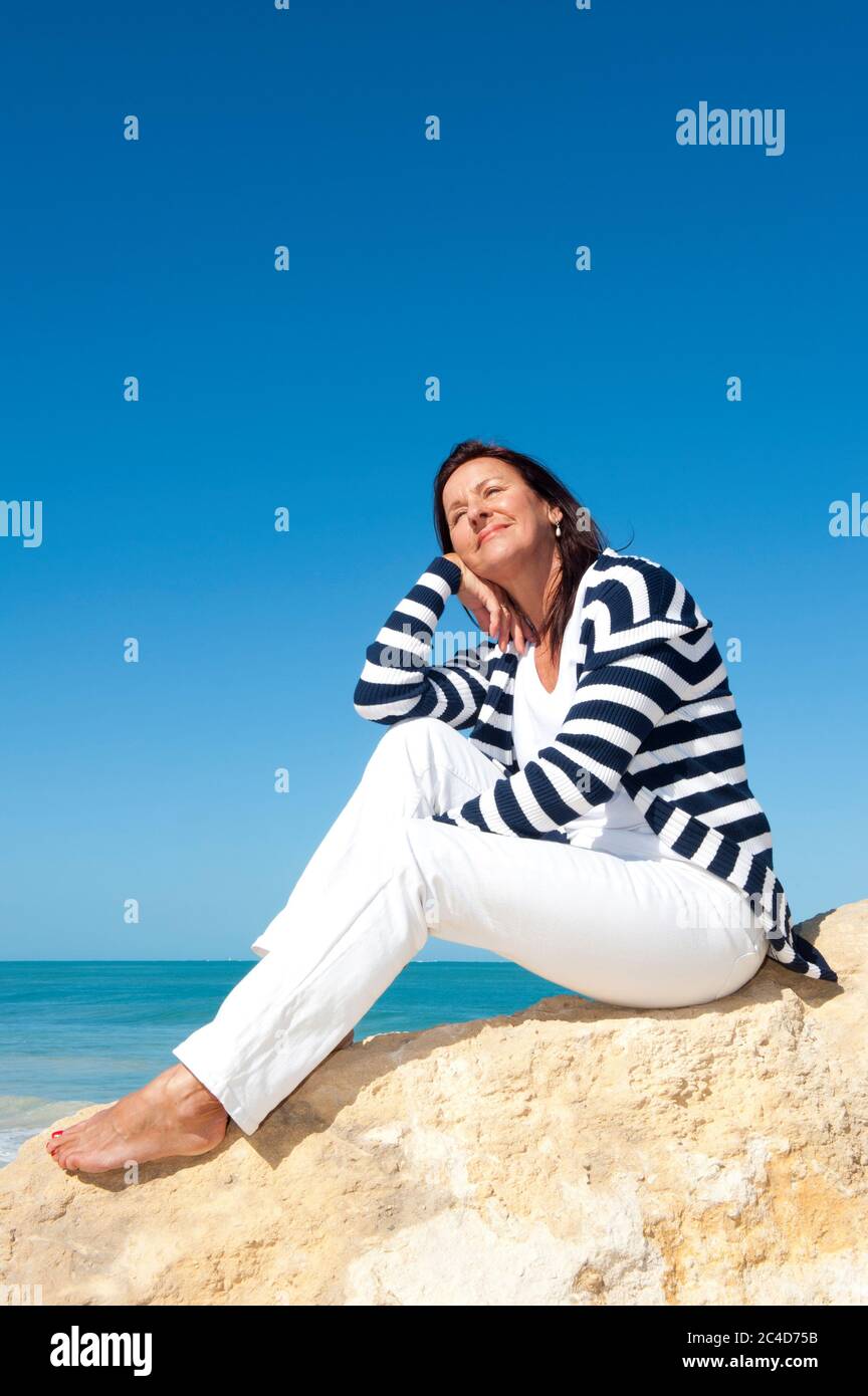 Glücklich selbstbewusst und attraktiv Senior Frau entspannte aktiven Ruhestand Urlaub auf See, isoliert mit Meer und blauen Himmel als Hintergrund und Kopierer Raum. Stockfoto
