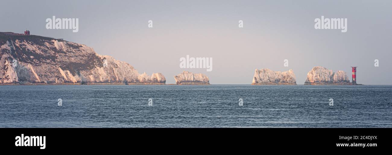 Die berühmten Nadeln felsigen Ausbissen einschließlich Leuchtturm in warmen getaucht Licht am frühen Morgen Stockfoto