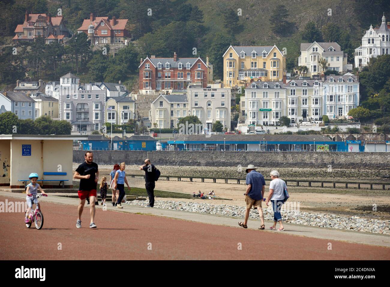 Llandudno, Nordwales, Strandpromenade mit bemalten Hotels in den Hügeln Stockfoto
