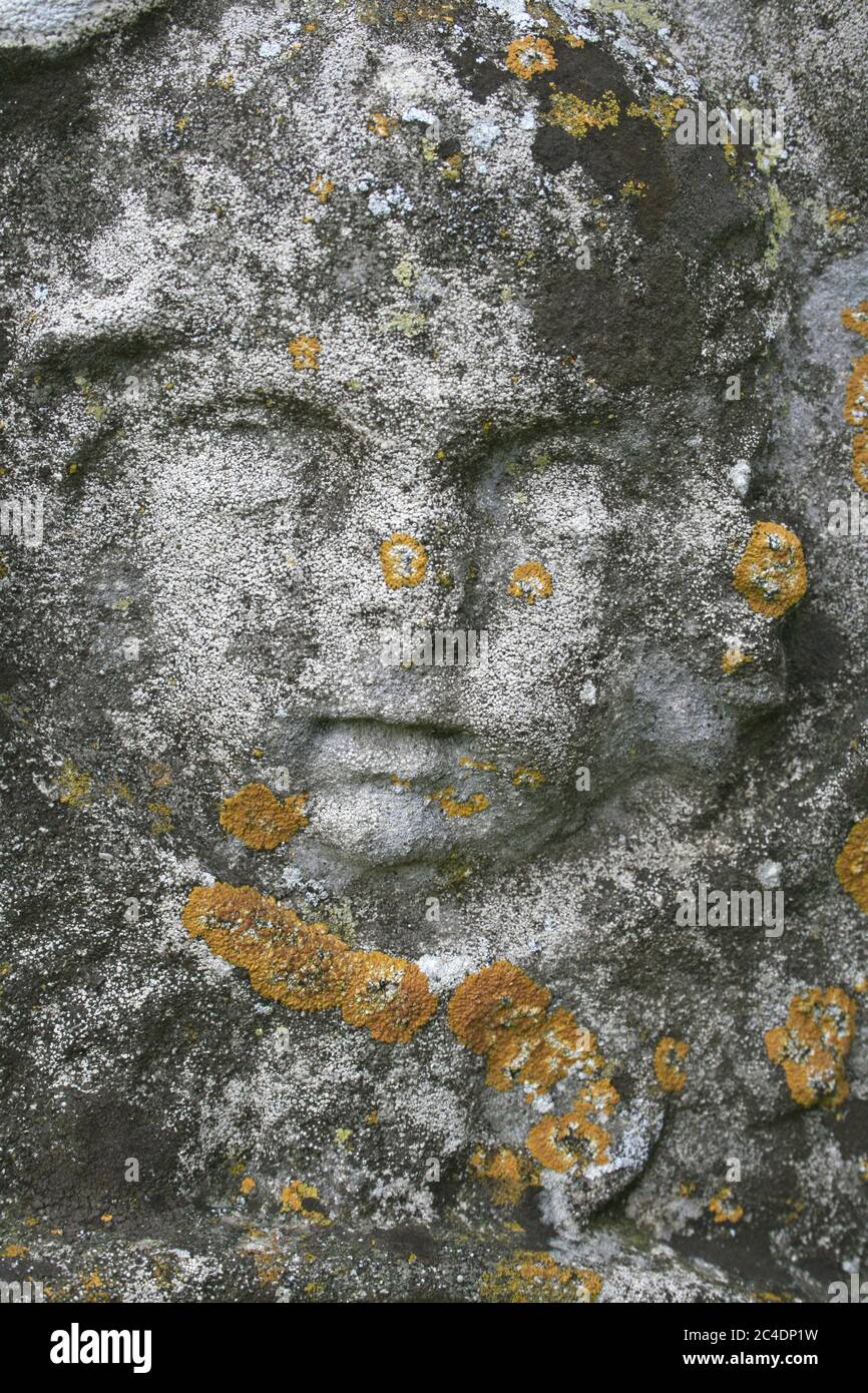 Grabstein Detail Von Childs Gesicht In Lichen Bedeckt Stockfoto