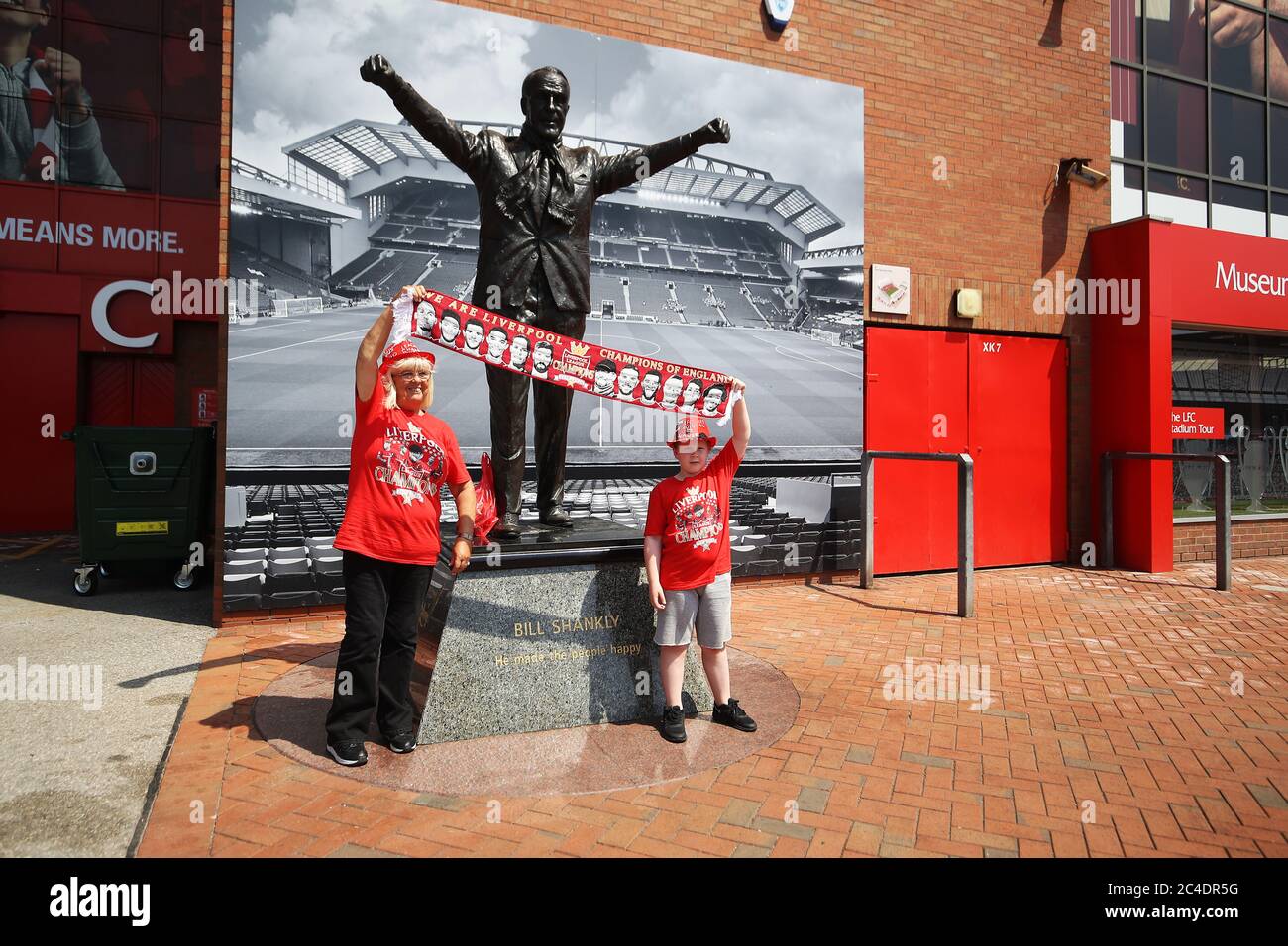 Liverpool-Fans Beryl Meland und Enkel Archie posieren für ein Foto mit der Bill Shankly Statue vor Anfield in Liverpool. Stockfoto