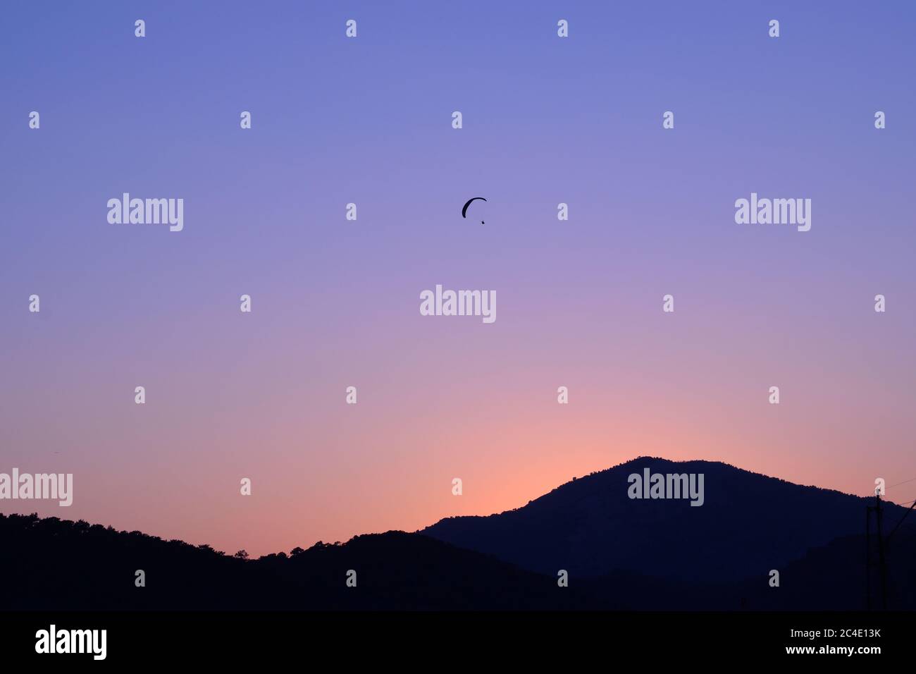 Ein Gleitschirm im Himmel über den Hügeln in Oludeniz, Türkei Stockfoto