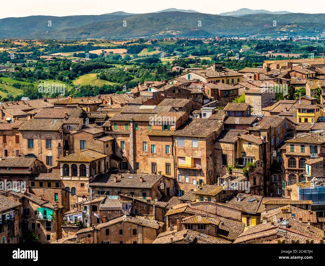 Luftaufnahme der Terrakotta-Ziegeldächer von Siena mit den toskanischen Hügeln in der Ferne. Siena. Italien. Stockfoto