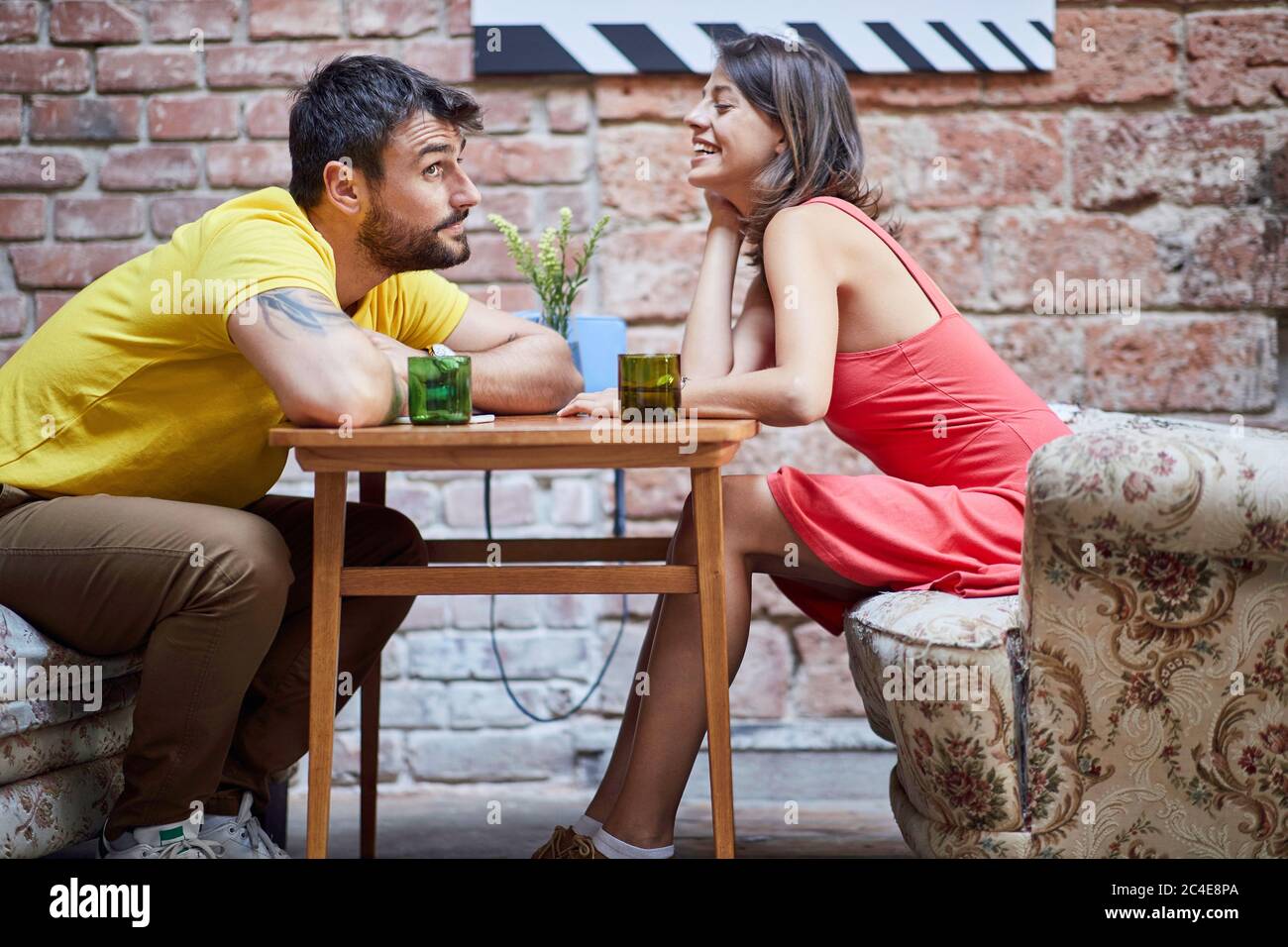 Nettes junges kaukasisches Paar flirtet über den Tisch in modernen Vintage-Café Stockfoto