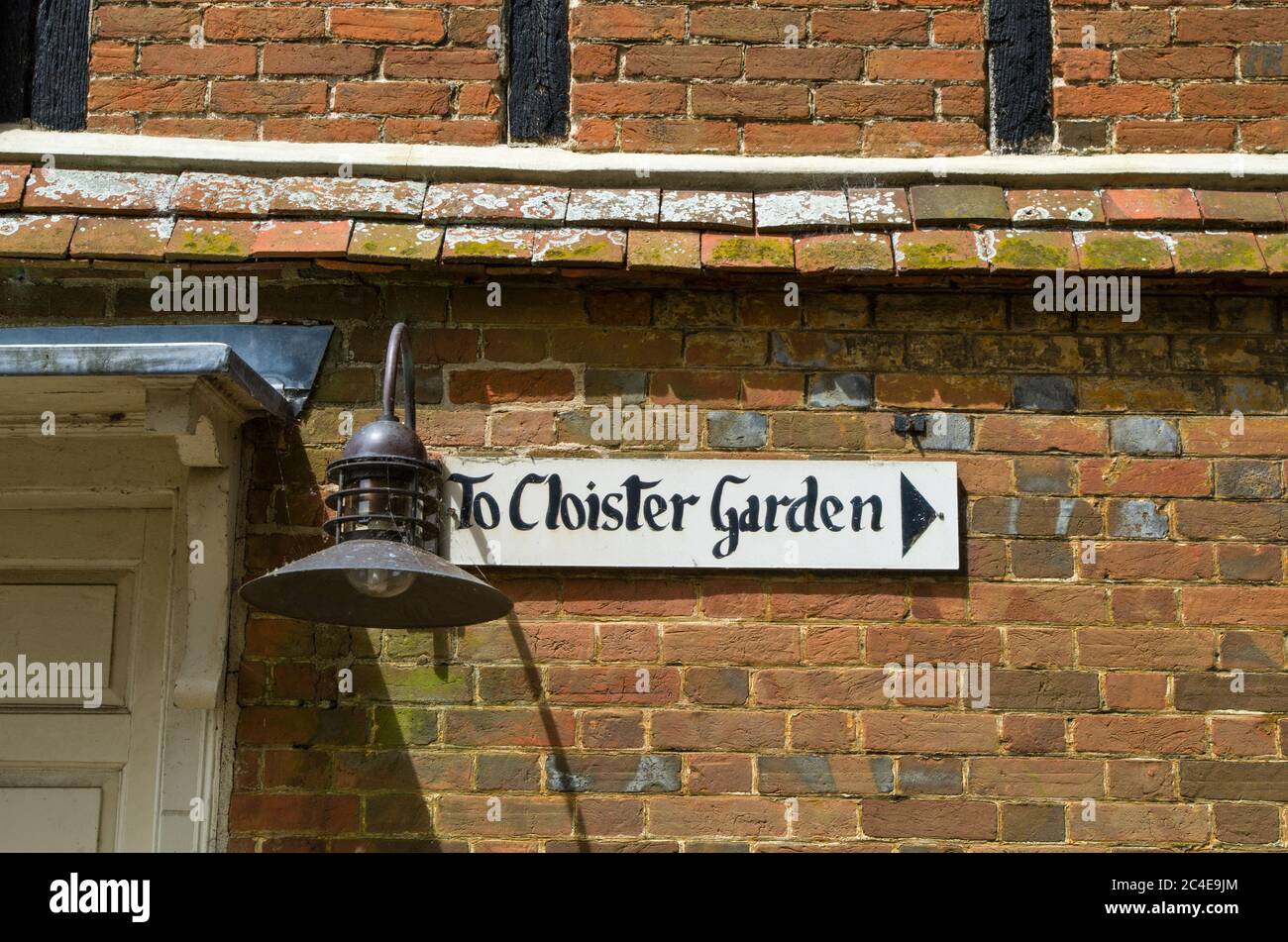 Gemaltes Schild an einer alten Ziegelwand, die auf den Cloiser Garden, Dorchester Abbey, Dorchester on Thames, Oxfordshire, UK, zeigt Stockfoto
