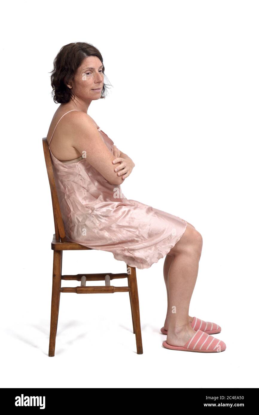 Seitenansicht einer Frau mit Nachthemd auf weißem Hintergrund sitzen, Seitenansicht Seite aussehen Stockfoto