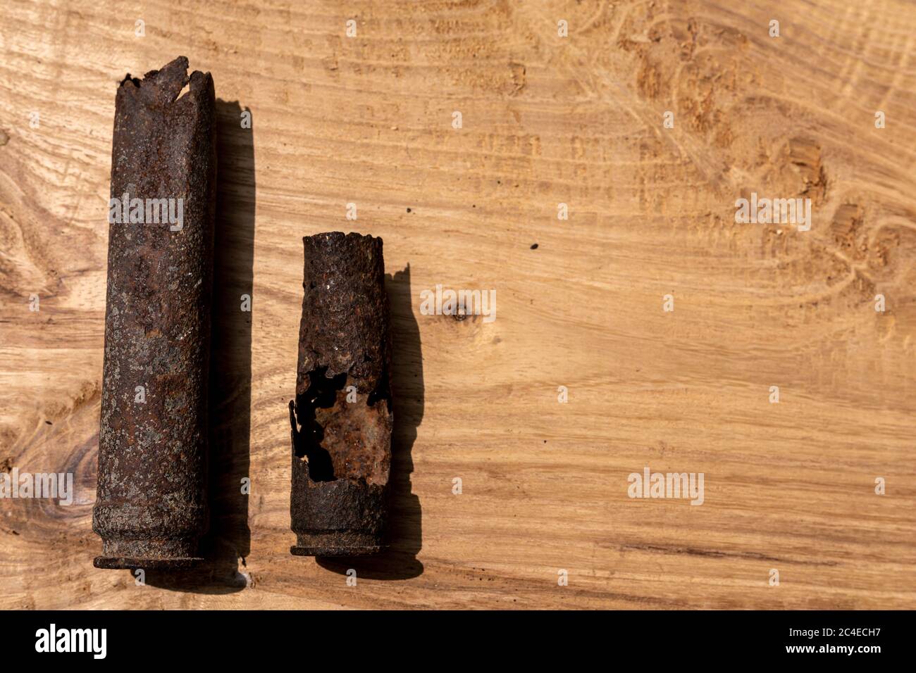 Alte rostige Artillerie-Shell und Flugzeuggeschossgeschoss auf Holzhintergrund, Geschosse Geschosse des 2. Weltkrieges gefunden, aus dem Boden ausgegraben Stockfoto