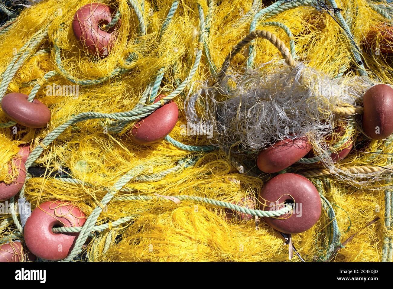 Gelbes Nylon-Fischernetz mit Schwimmleine an kleinen roten Kunststoff schwimmt befestigt Stockfoto