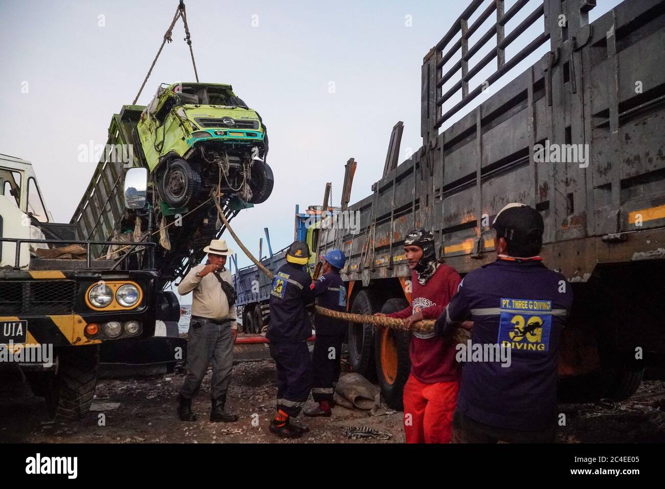 Karangasem, Bali, Indonesien. Juni 2020. Arbeiter ziehen den angehobenen LKW, um einen richtigen Platz auf dem Parkplatz zu bekommen. Ein LKW wird von einem Kran aus dem Meer gehoben. Passagierfähre (KMP) Dharma Rucitra III von Lombok Insel, die am 13. Juni im Padang Bai Hafen, Bali, gekentert wurde, noch während Evakuierungsversuch. Kredit: Dicky Bisinglasi/ZUMA Wire/Alamy Live Nachrichten Stockfoto