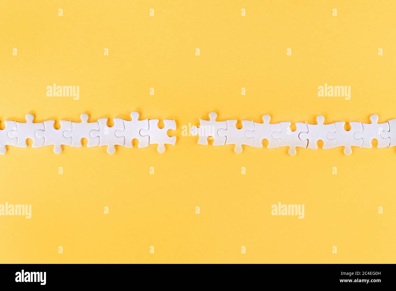 Zerrüttete Reihe von weißen Puzzle-Stücke mit fehlenden Link auf gelbem Hintergrund Stockfoto