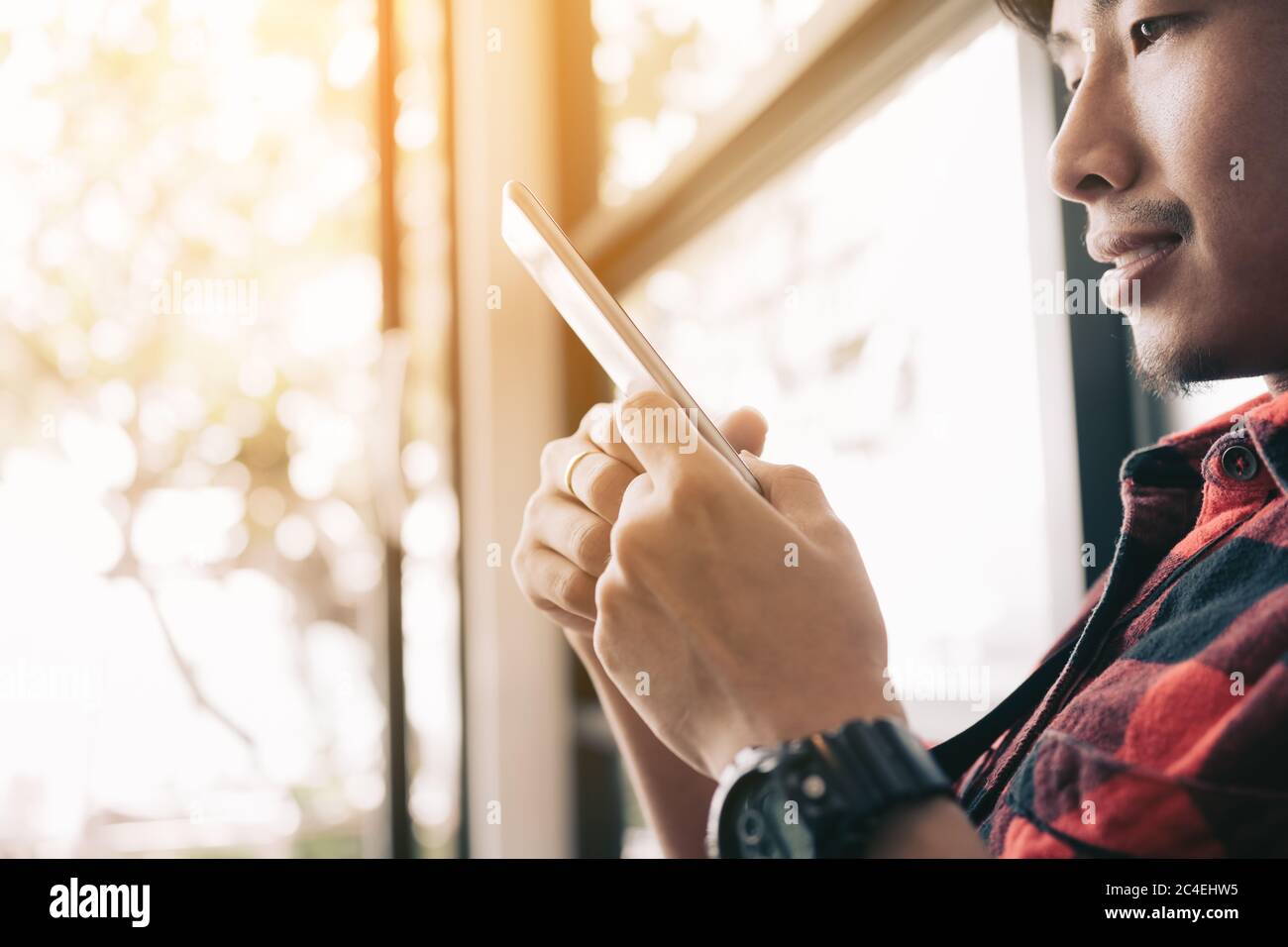 Asiatischer Mann mit Smartphone zu Hause. Stockfoto
