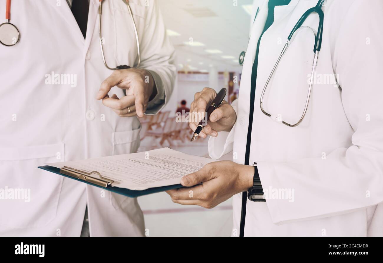 Medizinische Kollegen halten Zwischenablage mit Papier und arbeiten zusammen in Arztpraxis Stockfoto
