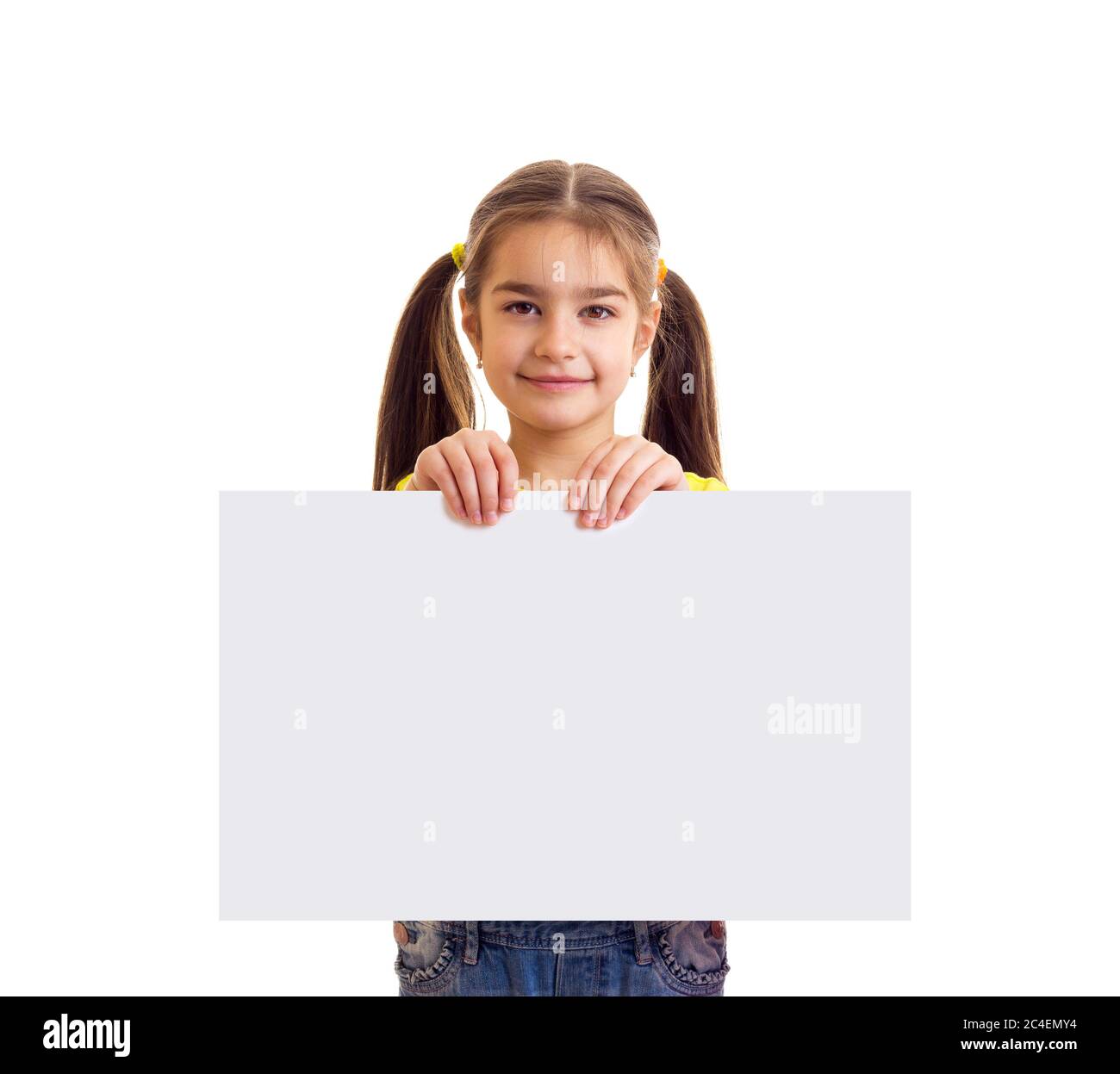 Kleines lächelndes Mädchen, das in der Kamera schaut und weißes Papierbanner hält Stockfoto