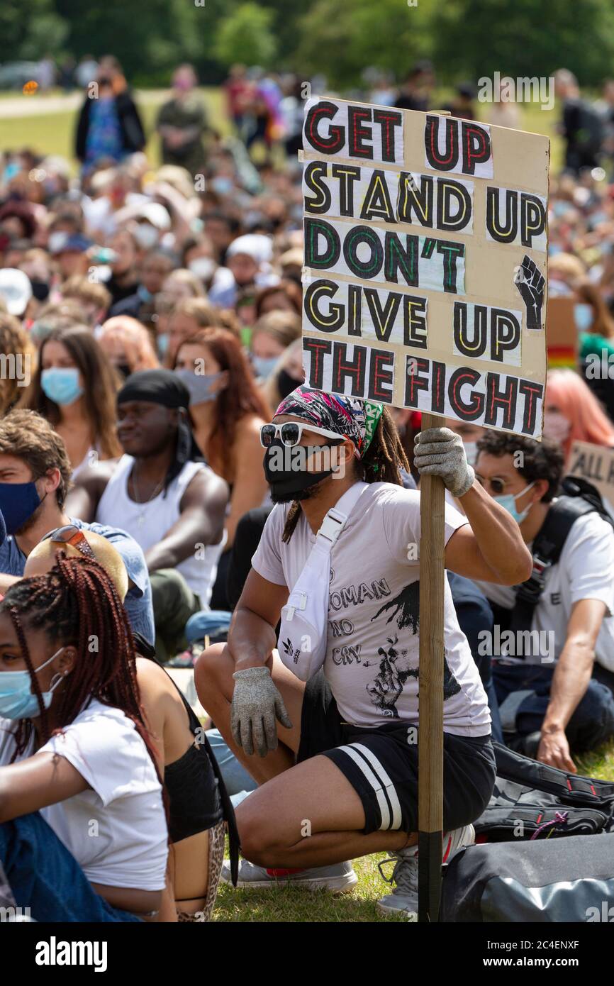Ein Mann hockt mit einem Protestschild unter einer Menschenmenge während einer Demonstration von Black Lives Matter, Hyde Park, London, 20. Juni 2020 Stockfoto Ein Mann hockt mit einem Protestschild unter einer Menschenmenge während einer Demonstration von Black Lives Matter, Hyde Park, London, 20. Juni 2020 Stockfoto
