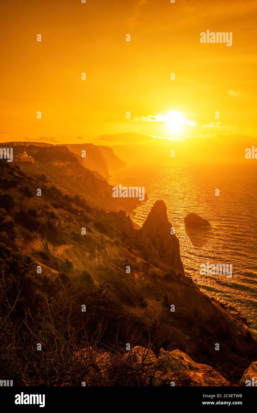 Ein rot brennender Sonnenuntergang mit der Silhouette einer Klippe über dem Meer. Speicherplatz kopieren. Das Konzept der Ruhe, Stille und Einheit mit der Natur. cape Fiolent Stockfoto