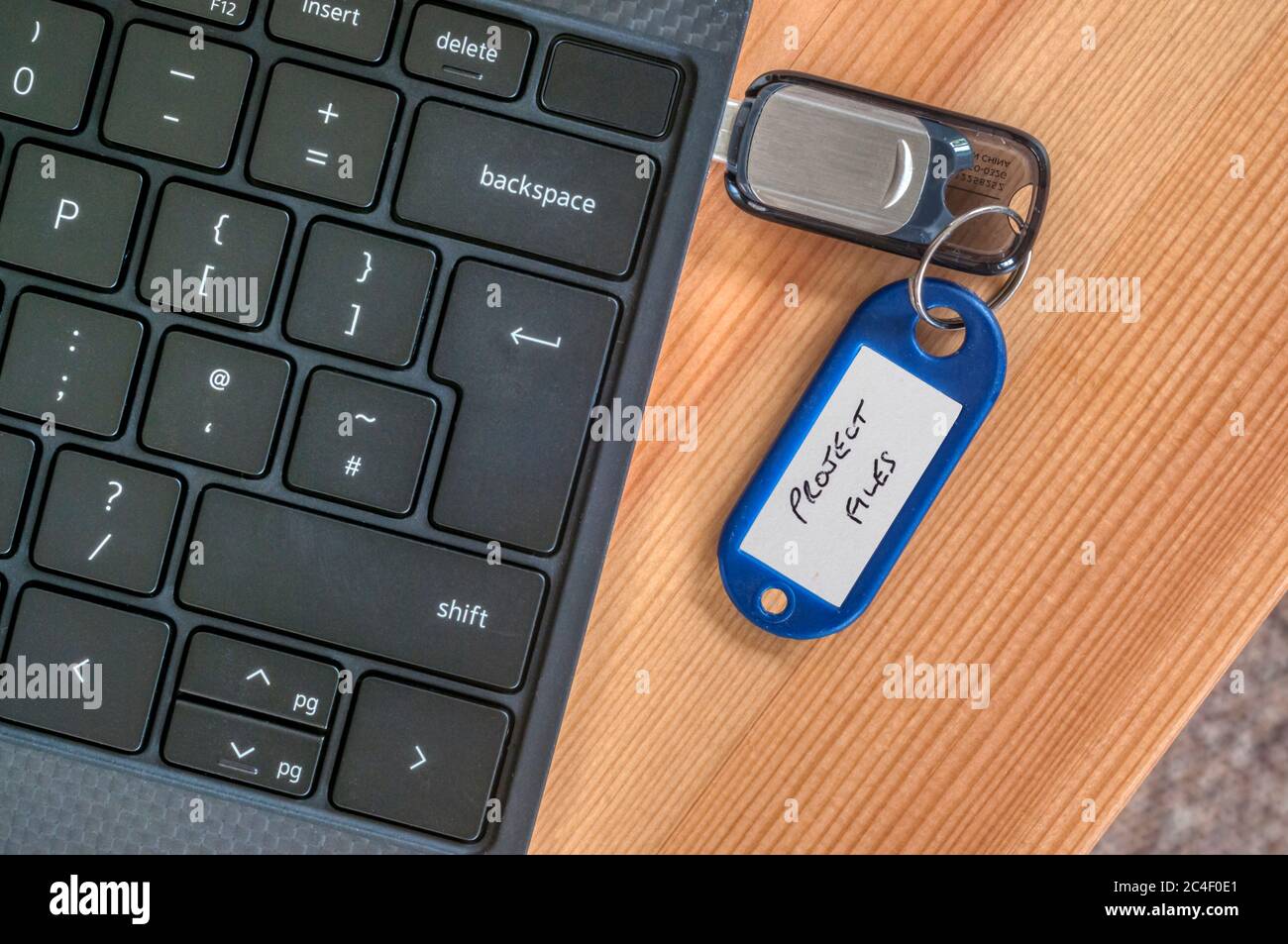 Projektdateien, die auf einem USB-Stick an der Seite eines Laptops gespeichert sind. Stockfoto