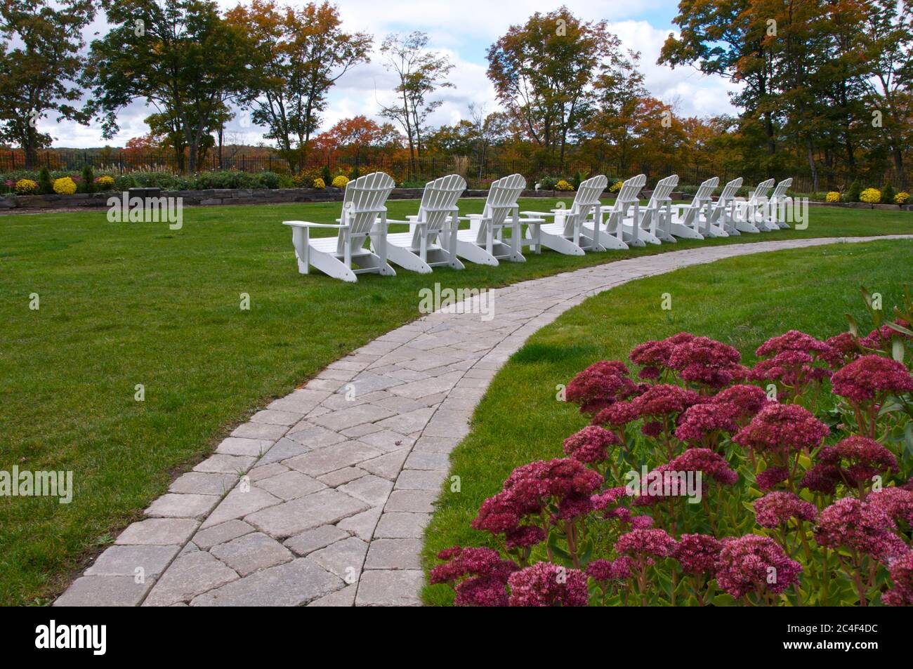 Weiße Muskoka-Stühle im Hinterhof eines touristischen Resorts. Stockfoto