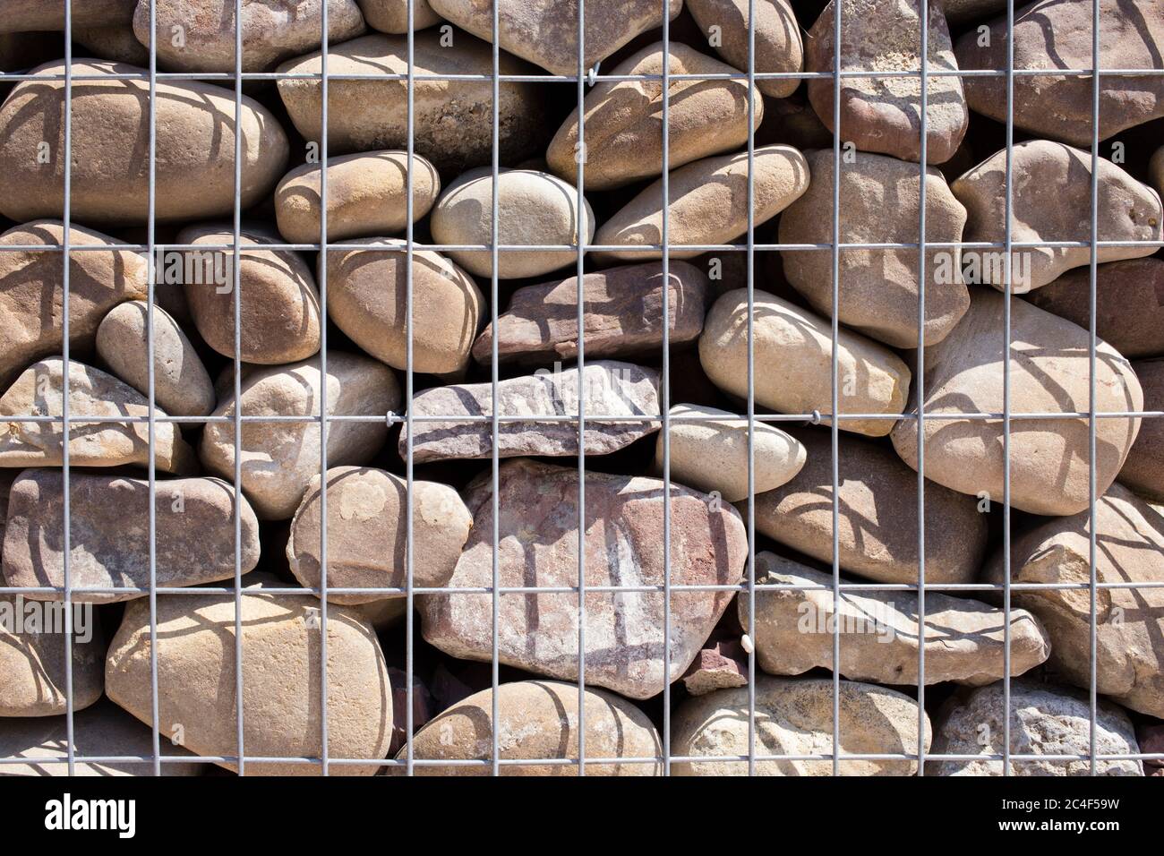 Eine moderne Form des Hauszäunens. Gabionsist aus verzinkten Stahlnetzen mit Spaltstein gefüllt. Nahaufnahme. Stockfoto