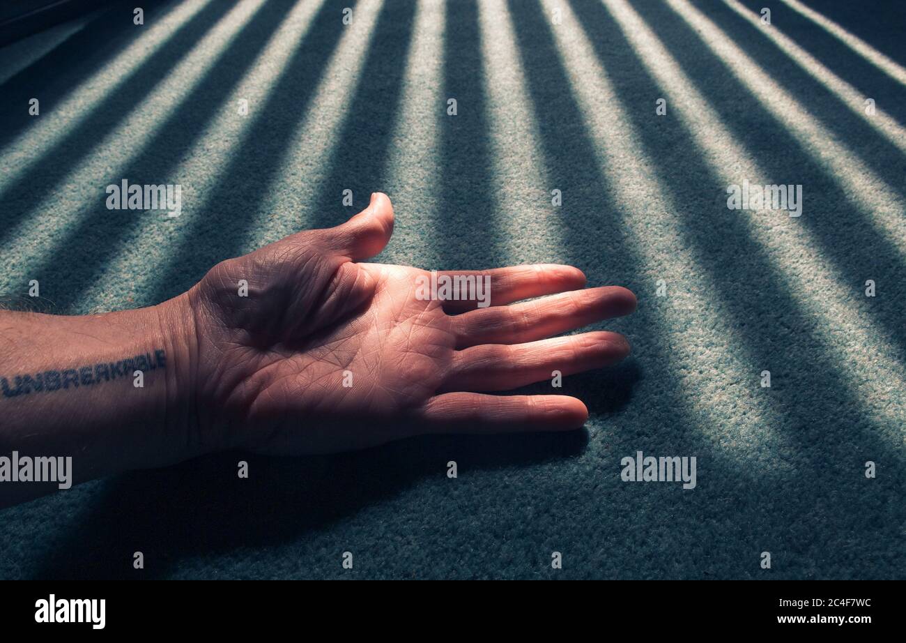 Männliche starke Hand unter Sonnenleuchten im Zimmer Stockfoto