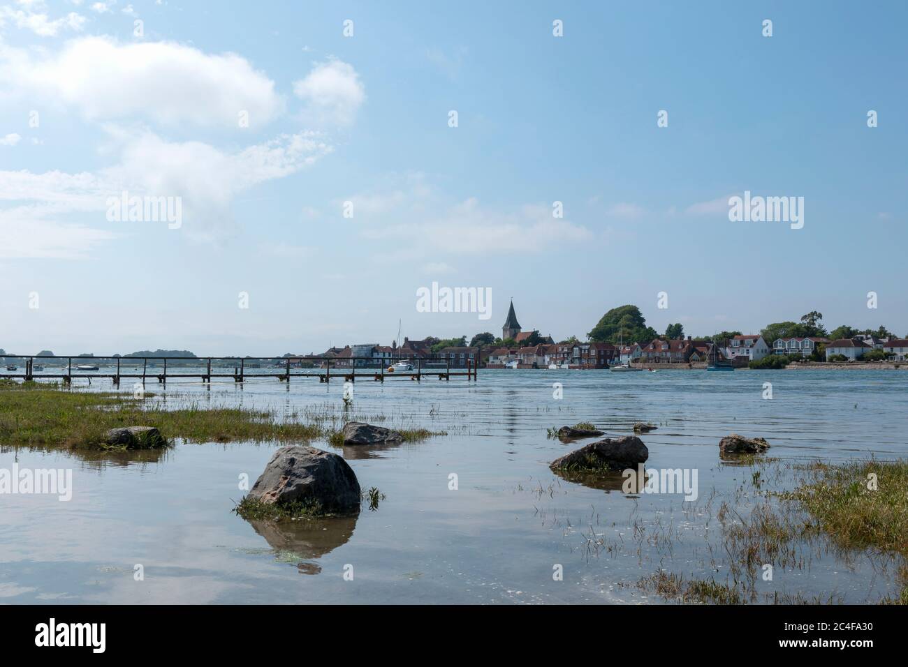 Hochflut Bosham in West Sussex über Chichester Hafen an einem Sommertag. Niedriger Winkel Blick auf das Dorf mit Überflutung im Vordergrund. Stockfoto